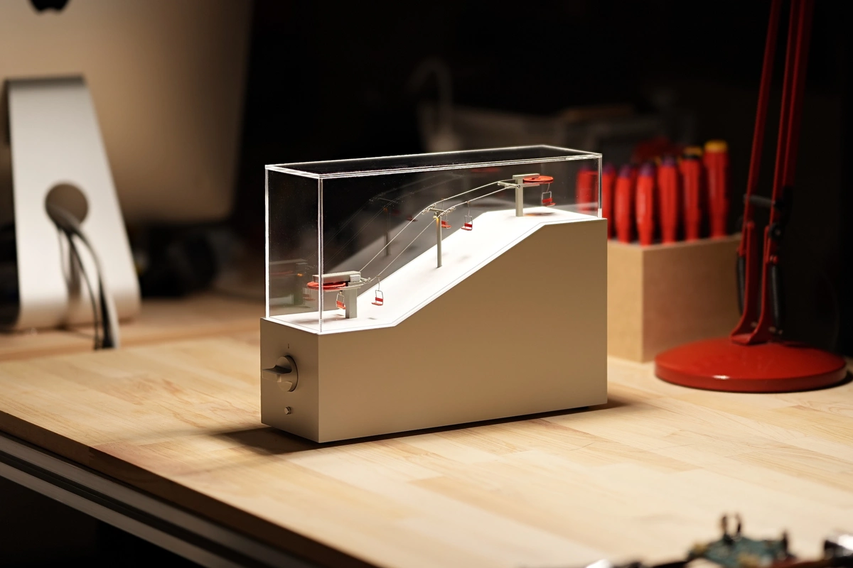 テーブルの上でデスクライトに照らされている、スキーリフトのミニチュアプロダクト『CL-1』